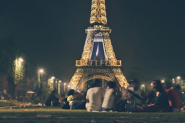 Group Of People Socialising In Front Of Eifel Tower At Night.jpg